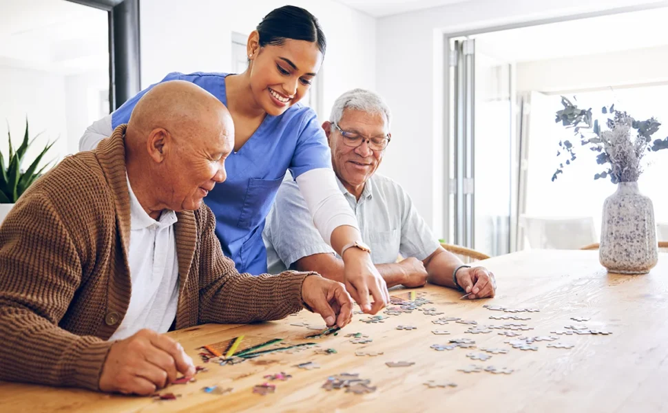 Residents and care giver doing a puzzle